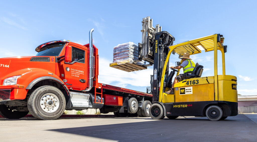 perator using an electric forklift from Papé Material Handling to load a pallet of lumber onto a Golden State Lumber delivery truck.