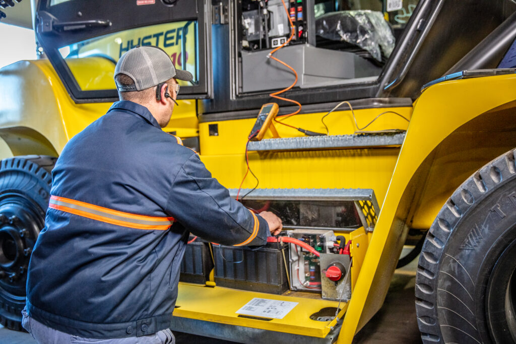 Forklift operator performing a pre-shift walk-around as part of preventive maintenance best practices.