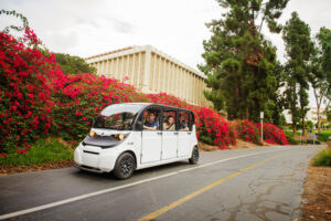 GEM E6 with doors moving passengers on street.