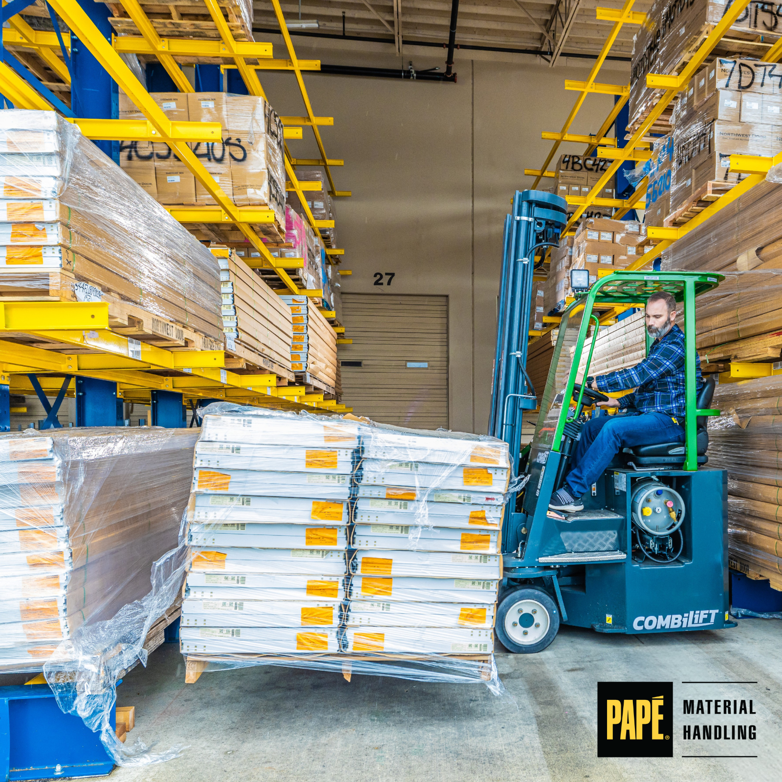 Combilift multi-directional forklift transporting long materials through narrow warehouse aisles