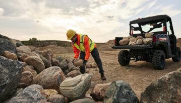 Heavy-duty Polaris UTV driving across an outdoor jobsite for demanding commercial work applications