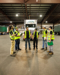 Warehouse team conducting a safety meeting and forklift inspection during OSHA Safe & Sound Week to improve workplace safety and hazard awareness